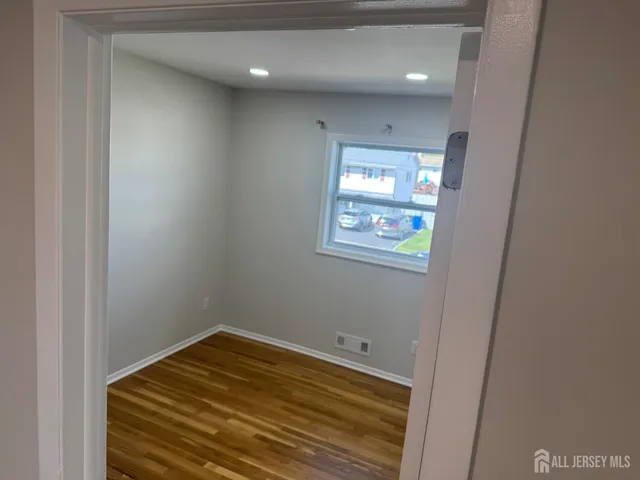 an empty room with wooden floor and closet