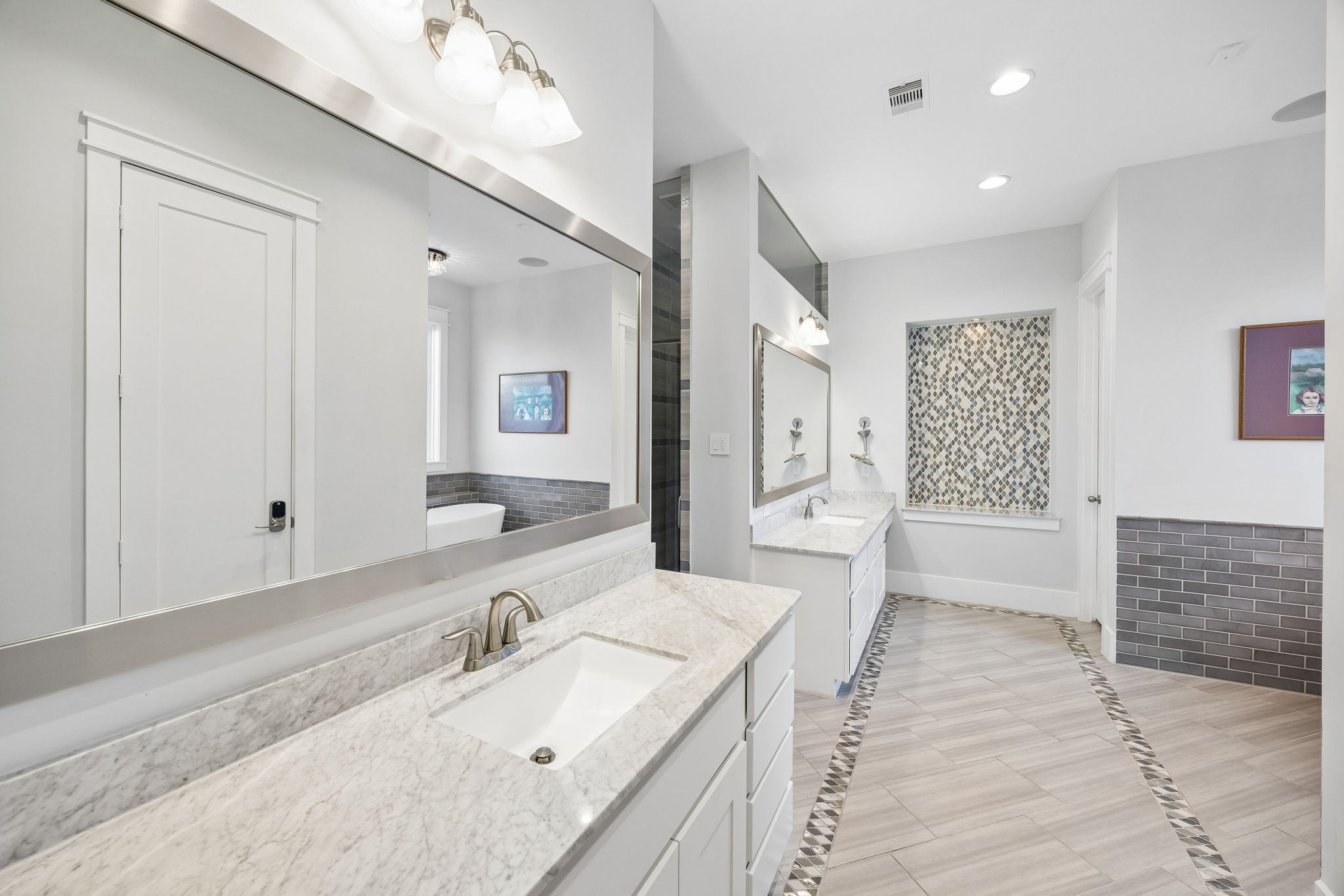 8558 Ridgepoint Drive Houston, TX 77055 - Photo 11 of 39 Expansive mirrors and a long vanity bring light and everyday function to the primary bathroom.