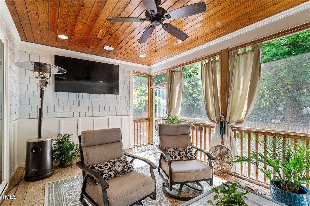2613 Bedford Avenue Raleigh, NC 27607 - Photo 34 of 44 a living room with furniture a flat screen tv and floor to ceiling window
