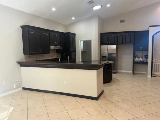 a kitchen with kitchen island a counter top space cabinets and stainless steel appliances