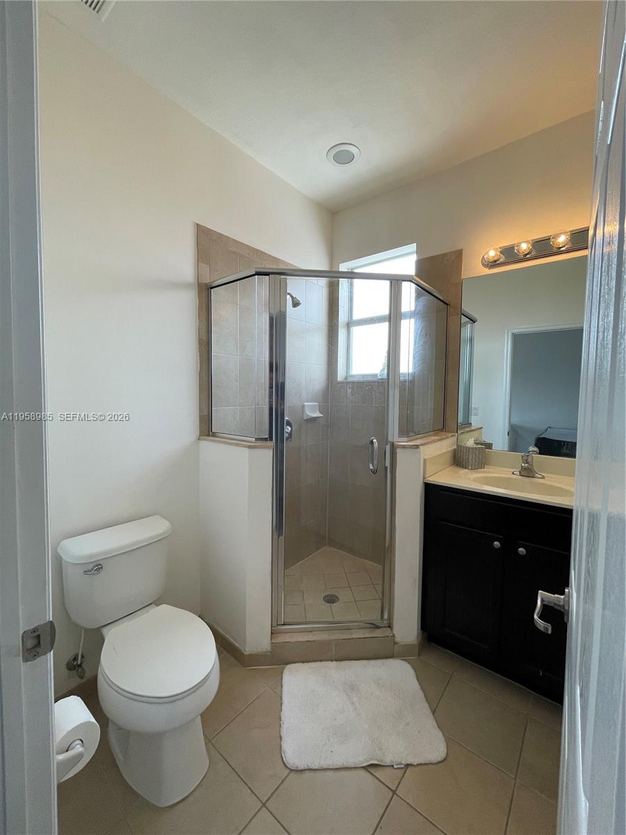 9242 Southwest 171st Court, Unit A Miami, FL 33196 - Photo 5 of 7 a bathroom with a toilet a sink and shower