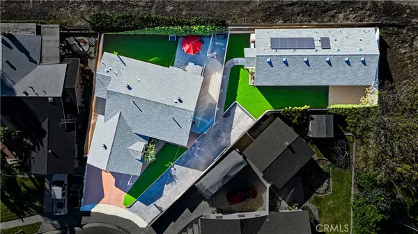 an aerial view of a house with a yard fire pit and furniture