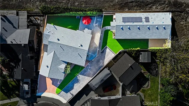 an aerial view of a house with a yard fire pit and furniture