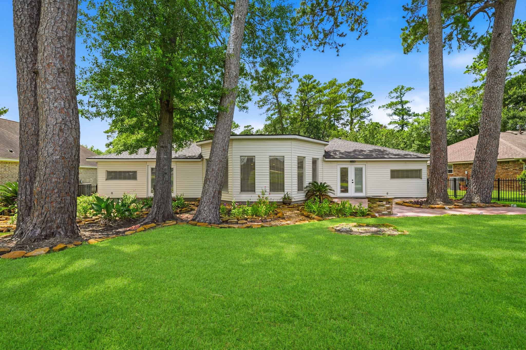 79 Summers Wind Street Conroe, TX 77356 - Photo 35 of 45 a front view of a house with a garden and trees