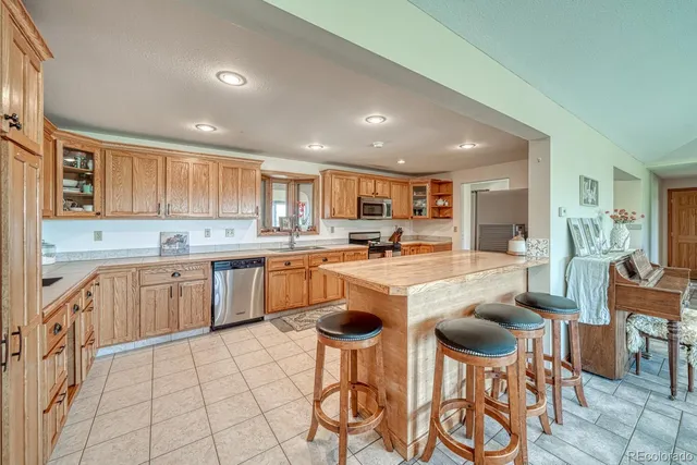 a kitchen with cabinets and chairs