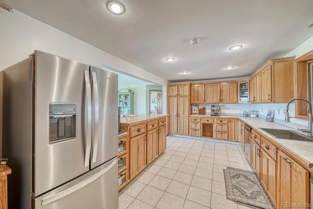 a large kitchen with stainless steel appliances granite countertop a refrigerator and a sink