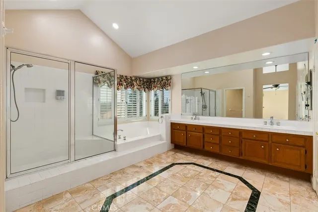 a spacious bathroom with a tub sink shower and mirror