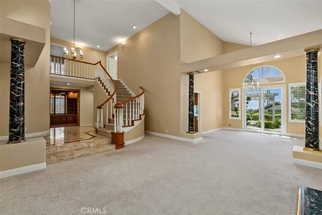 a view of an empty room with stairs and a floor to ceiling window