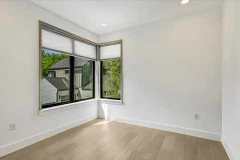an empty room with wooden floor and a window