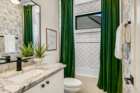 a bathroom with a granite countertop sink toilet and shower