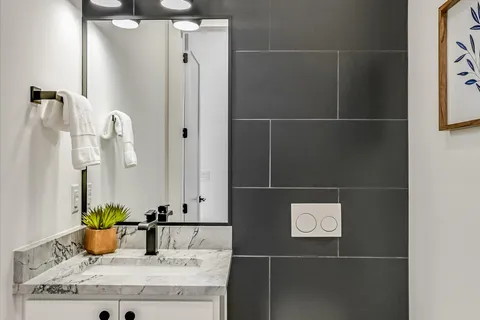 a bathroom with a granite countertop sink and a mirror