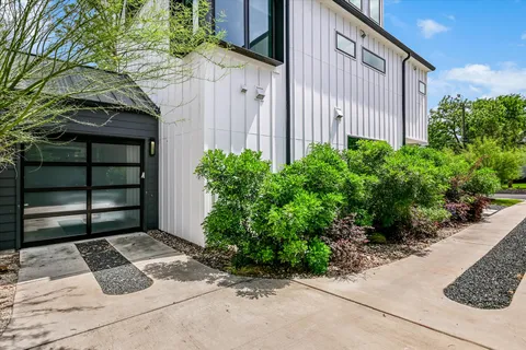 a backyard of a house with potted plants and brick wall