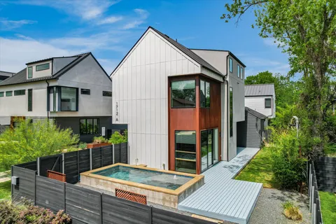 a backyard of a house with potted plants and wooden fence