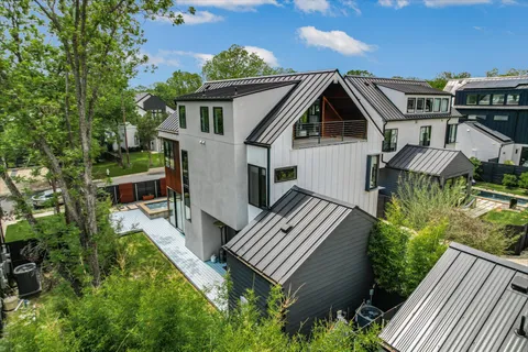 an aerial view of house with yard and trees in the background