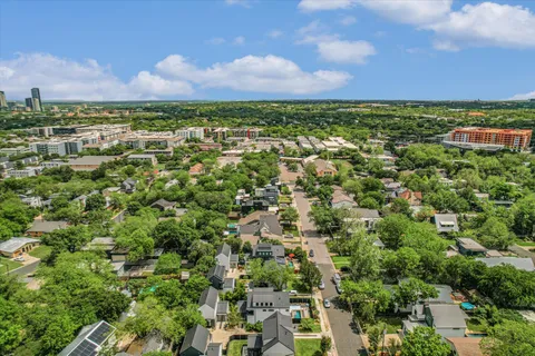 an aerial view of residential houses with outdoor space and trees