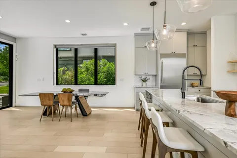 a kitchen with a table chairs a sink dishwasher window and cabinets