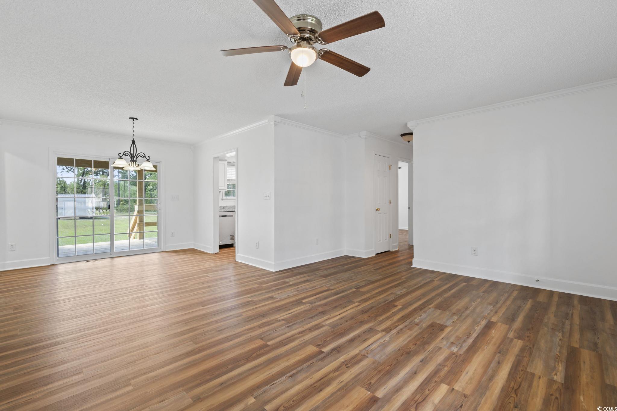 568 Rosedale Drive Aynor, SC 29511 - Photo 8 of 38 Unfurnished living room featuring a chandelier, wood finished floors, ornamental molding, a ceiling fan, and a textured ceiling