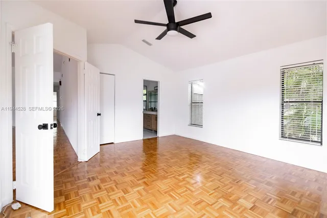 a view of empty room with wooden floor and window