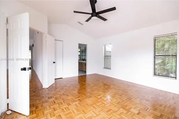 a view of empty room with wooden floor and window