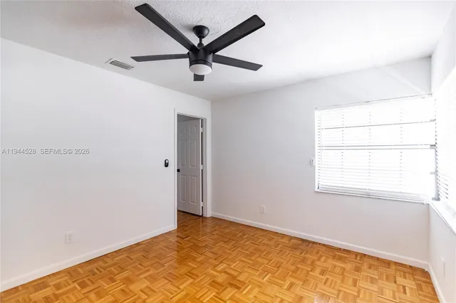 a view of a big room with wooden floor and windows in a room