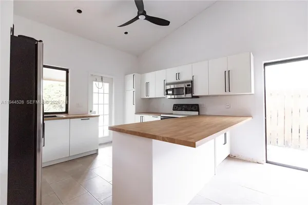 a kitchen with kitchen island a counter top space a sink stainless steel appliances and cabinets