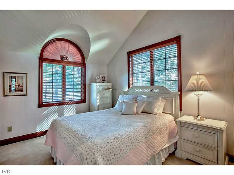 1155 Lakeshore Boulevard Incline Village, NV 89451 - Photo 14 of 18 a bedroom with a bed and a chandelier