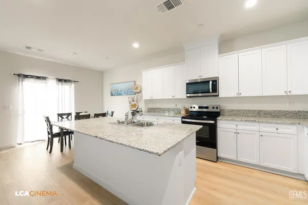 a kitchen with granite countertop appliances cabinets and a table