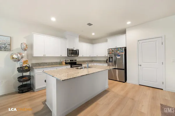 a kitchen with a sink a refrigerator and cabinets