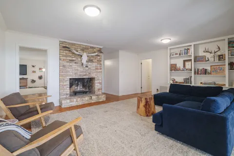 a living room with furniture a fireplace and a flat screen tv
