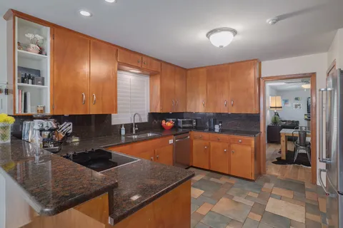 a kitchen with stainless steel appliances granite countertop a sink stove and refrigerator