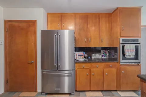 a kitchen with stainless steel appliances granite countertop a refrigerator and a stove