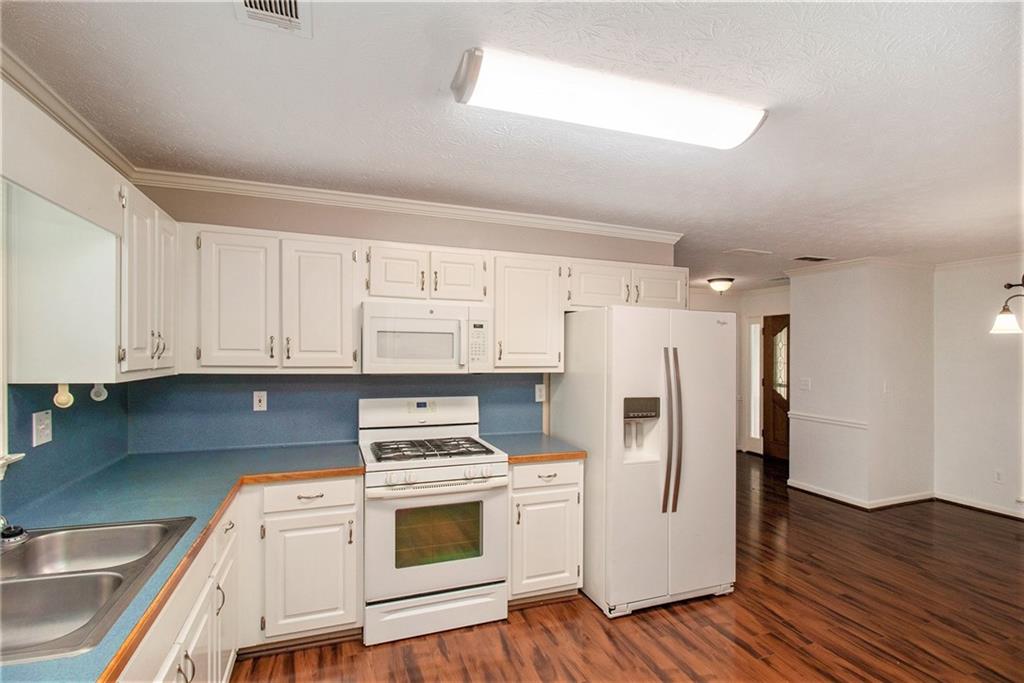 340 Radcliff Trace Covington, GA 30016 - Photo 12 of 38 a kitchen with stainless steel appliances a refrigerator sink and cabinets