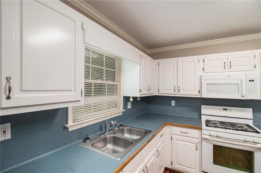 340 Radcliff Trace Covington, GA 30016 - Photo 14 of 38 a kitchen with granite countertop a sink stove and cabinets