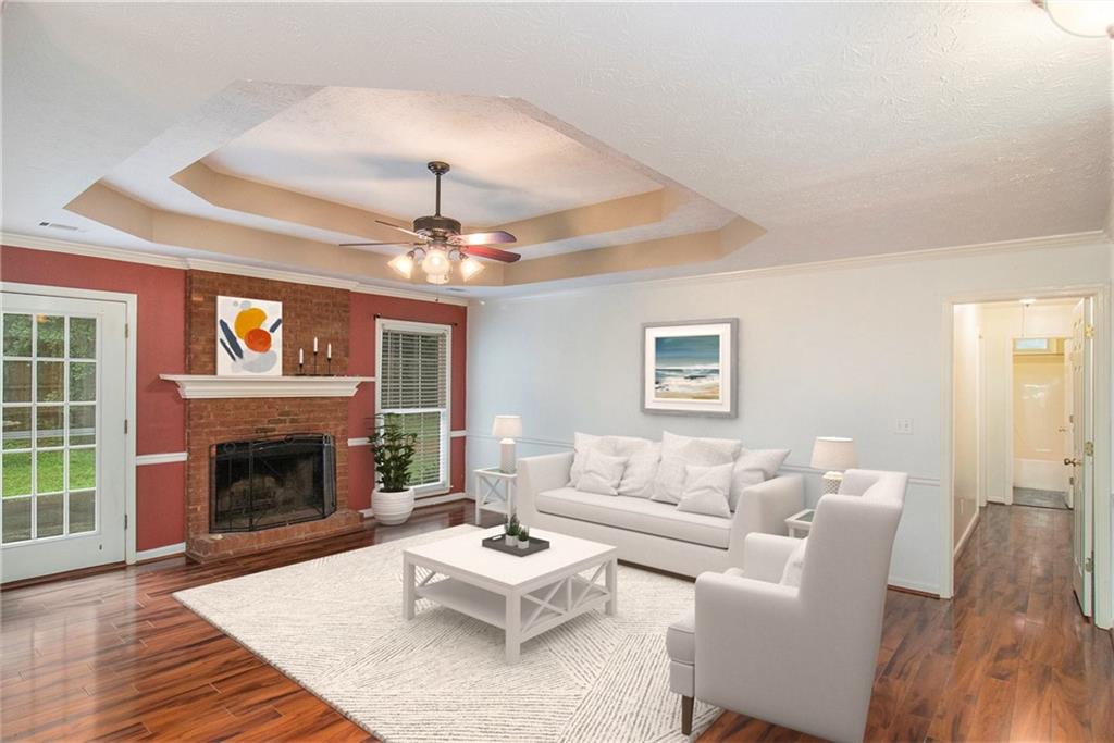 340 Radcliff Trace Covington, GA 30016 - Photo 7 of 38 a living room with furniture a chandelier and a fireplace