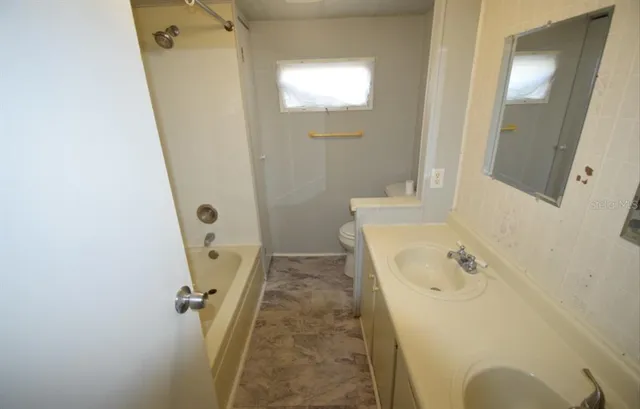 a bathroom with a tub sink and mirror