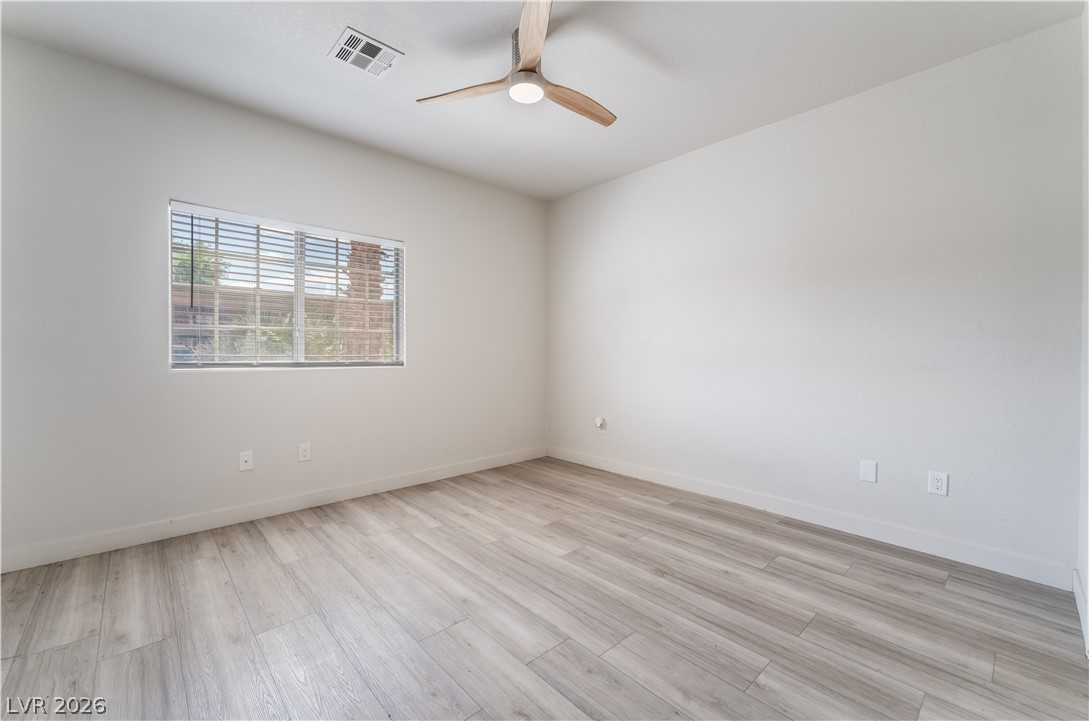 4730 East Craig Road, Unit 1058 Las Vegas, NV 89115 - Photo 15 of 30 A well-lit bedroom with modern wood-look flooring and a contemporary ceiling fan offers comfortable living.