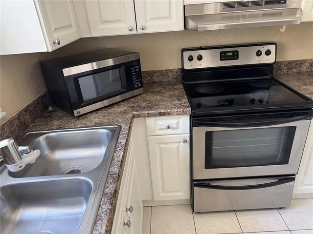 a kitchen with granite countertop a stove and a microwave