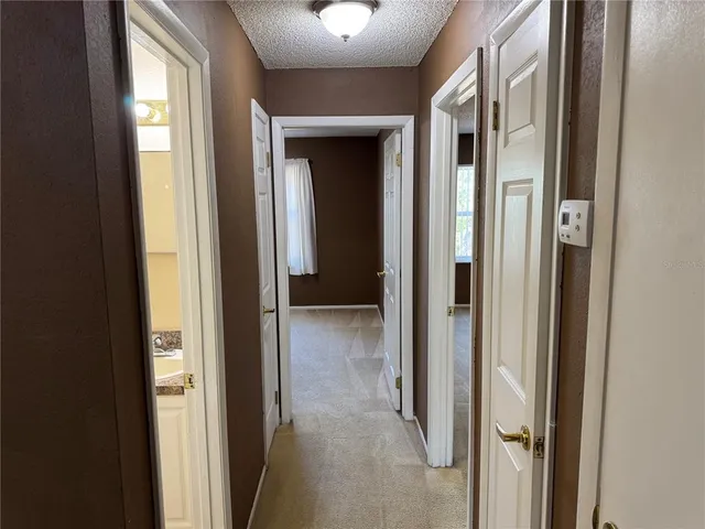 a view of a hallway with wooden floor and closet