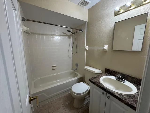 a bathroom with a granite countertop sink toilet mirror and shower