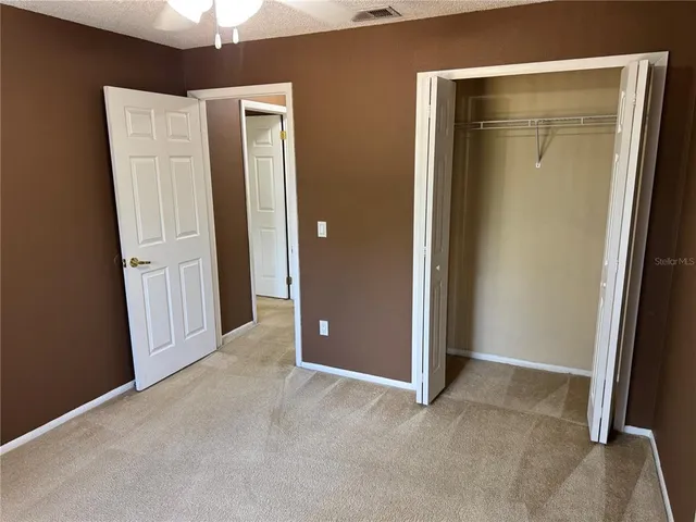 an empty room with closet and a hallway