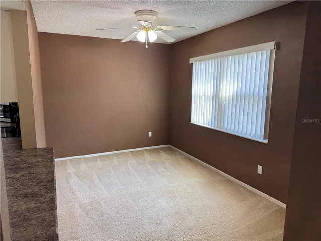 an empty room with windows and fan