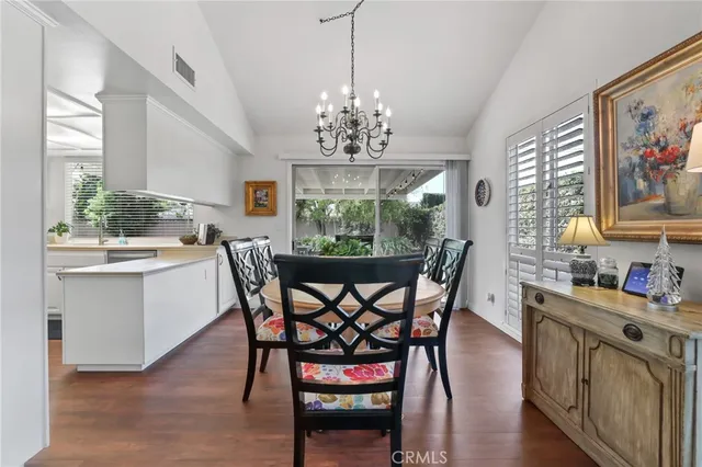 a dining room with furniture a chandelier and wooden floor