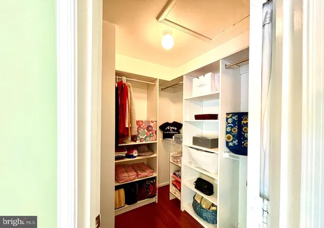 a view of walk in closet with clothes and shoes