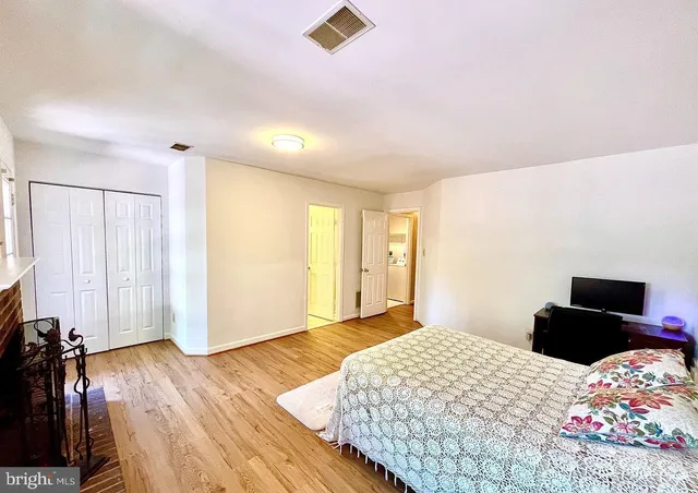 a bedroom with a bed and wooden floor