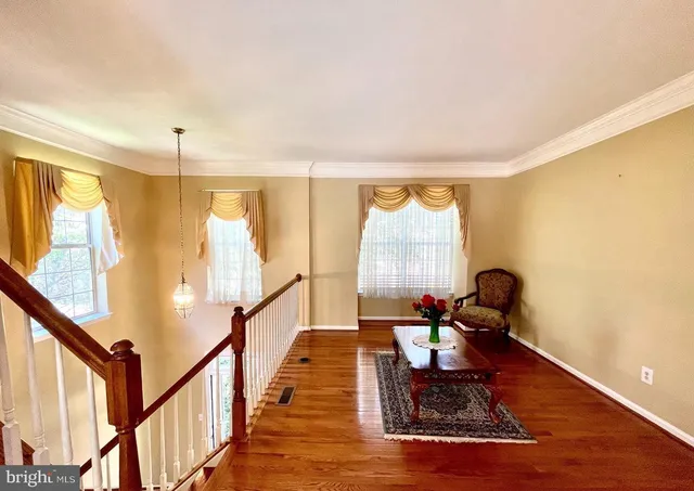 a living room with wooden floor furniture and a large window