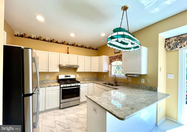 a kitchen with kitchen island granite countertop stainless steel appliances a stove center island a stove and a window