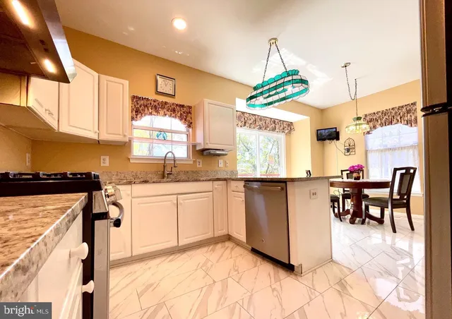 a kitchen with granite countertop a stove a sink and a refrigerator