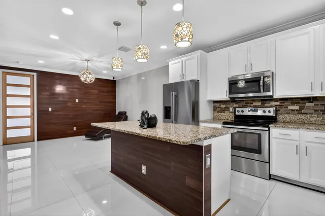 a kitchen with stainless steel appliances granite countertop a stove and a sink