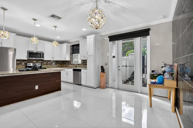 a kitchen with stainless steel appliances kitchen island granite countertop a refrigerator and a sink
