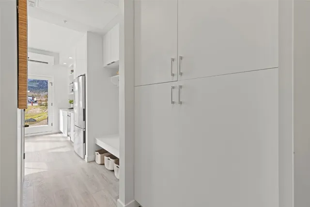 a view of a hallway with wooden floor and a bathroom